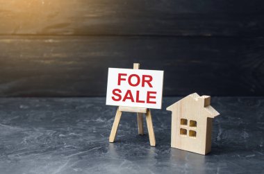 Satılık bir tabela ile ahşap ev standı. Bir ev ya da daire ve mülk satmak. konut ve gayrimenkul. Gayrimenkul satış hizmetleri. Yatırım. konut veya kira. Mortgage, satın alma kredisi