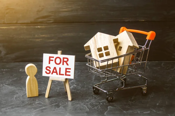 Supermarket cart with houses and man with a poster for sale. The concept of selling a home, real estate services or buying from the owner. Buying and selling real estate, property, apartments