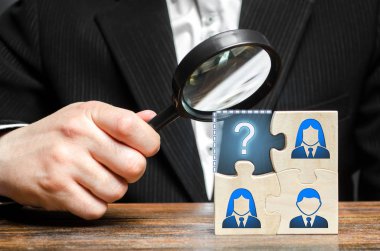 Büyüteçli işadamı bulmaca ekibinin eksik kısmını inceliyor. Arama, işe alım personeli, elebaşı. Etkili bir iş ekibi oluşturmak. İşgücü piyasasında uzman eksikliği