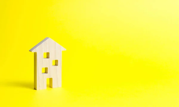 Дерев'яний житловий будинок на жовтому тлі. Ізольована концепція нерухомості, купівля доступного житла, продаж нерухомості та оренда. Іпотека та кредит на купівлю. Мінімалізм. Податок на майно — стокове фото