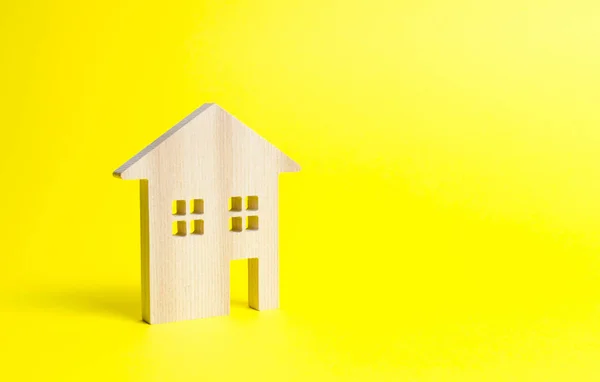 Дерев'яний житловий будинок на жовтому тлі. Іпотека та кредит на купівлю. Мінімалізм. Ізольована концепція нерухомості, купівля доступного житла, продаж нерухомості та оренда. Податок на майно — стокове фото