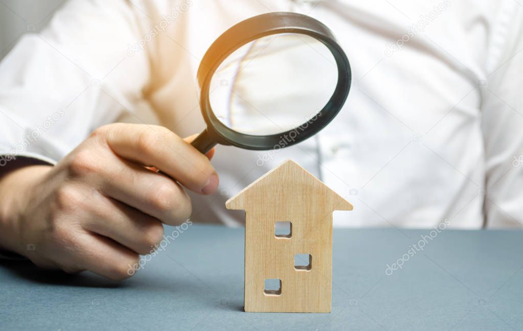 Wooden house and magnifying glass. Property valuation. Choice of location for the construction. House searching concept. Search for housing and apartments. Real estate concept. Home appraisal