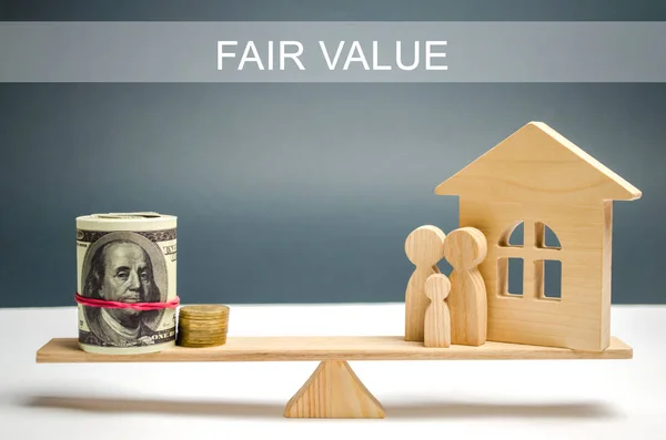 Money and family with a house on the scales with the inscription Fair value. Property valuation. Home appraisal. Housing evaluator. Fair trade. Legal transparent deal. Apartment purchase / sale. — Stock Photo, Image