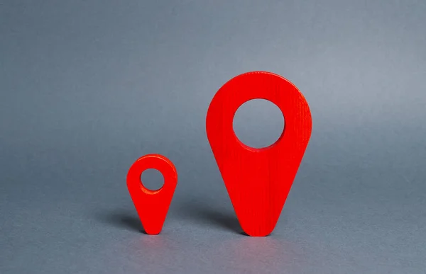 Kleine en grote rode navigatie locatie-indicatoren. Het concept van een meer belangrijke en populaire plek. Competitie. Aankomstpunt meet afstand en bouw een route. — Stockfoto