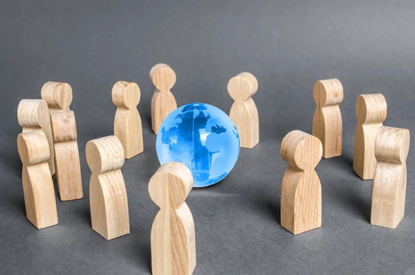 People surrounded a Globe world planet earth. Cooperation and collaboration of people around the world. Outsourcing and joint work on projects. Diplomacy. crowdfunding. Preserving environment — Stock Photo, Image