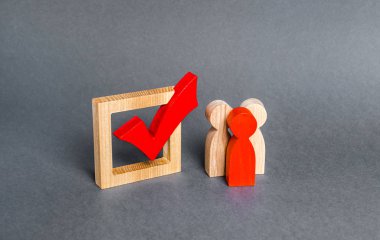 People figurines stand near the checkbox for voting in democratic elections. Lobbying interests, voter bribery, and rigging presidency or parliamentary election results. expression of will clipart