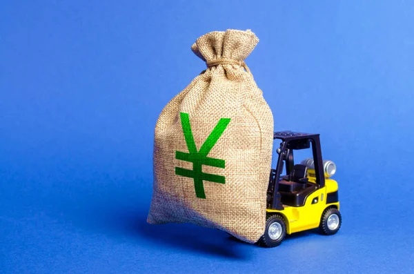 Yellow forklift carries a money bag with Yen or yuan symbol. Concept of a major contract, profitable deposit or loan. Payment of taxes. escape of investors from the country. Business economics