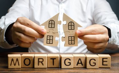 Bir adam yazıt Mortgage üzerinde bütün bir eve iki bulmaca bağlanır. Kendi konut binanızın inşaatı. Kredi kredisi ile ev satın almak, yaşam koşullarının iyileştirilmesi