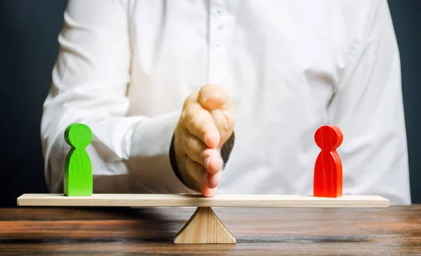 Wooden figures of people on scales and a mediator / arbitrator. Resolving conflict situations and disputes. Conclusions of the peaceful resolution of disputes. Conflict of interest. Business opponents — Stock Photo, Image