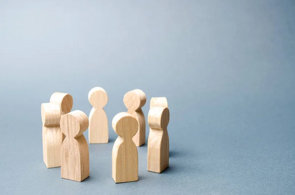 People stand in a circle on a gray background. Wooden figures of people. A circle of people. discussion, cooperation, cooperation. Communication. Business team, teamwork, team spirit. Selective focus — Stock Photo, Image