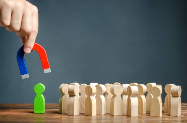 Mıknatıslı bir el kalabalığın içinden yeşil bir insan figürü çıkarmaya çalışıyor. Yeni işçiler işe almak. Yeni bir iş ekibinin kurulması. Büyük kariyer potentia ile yetenekli işçiler için arama.