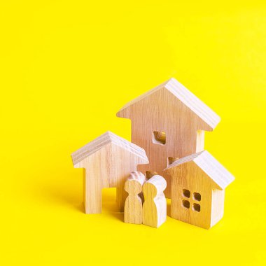 Üç ev ve sarı arka plandaki insanlar. Gayrimenkul alım satımı, inşaat. Bir şehir veya yerleşim de daire ve konut binaları. Yatırım. mortgage kredisi.