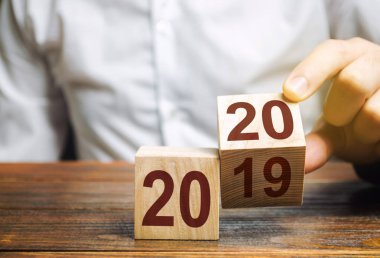 2019 ve 2020 numaraları ile iki ahşap blok. Yeni yılın başlangıcı kavramı. Yeni hedefler. Gelecek on yıl. Trendler ve dünyadaki değişiklikler. Planlar ve hedefler oluşturun. Zaman raporu