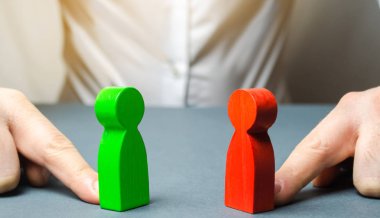 Adam kırmızı ve yeşil figürleri birbirine doğru iter. Uzlaşma arayışı, müzakerelerde arabuluculuk. çıkar çatışması Analizi, durum. Uyuşmazlığın taraflarının uzlaştırılması