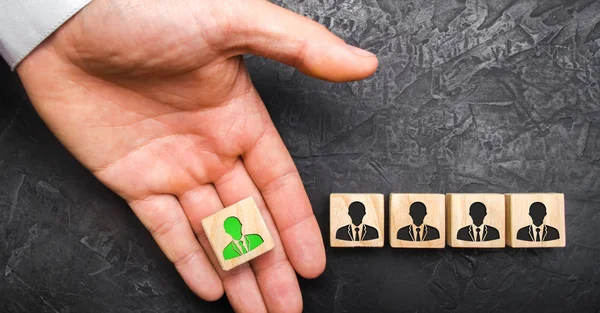 Рука простягає зелену фігуру лідера до команди співробітників. Headhunter новобранців персоналу та управління бізнес-персоналом. Концепція пошуку фахівців і робітників на роботі. — стокове фото