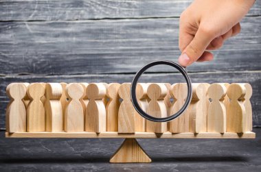 Büyüteç, ölçekte büyük bir insan kalabalığına bakıyor. İnsanlar görüş olarak belirlenemez. düşünce kavramı ve partilerin seçimi, toplumun ve devletin gelişimi