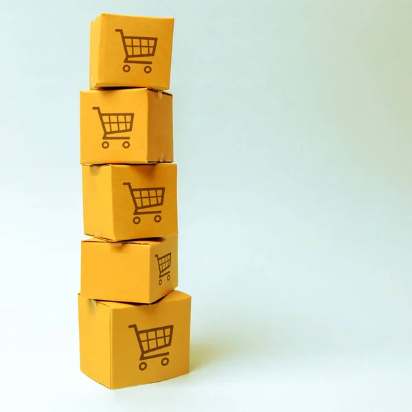 Tower of cardboard boxes with pattern of shopping carts on a blue background. commerce, online shopping. E-commerce, logistics, distribution and sales. Purchasing power, delivery order.