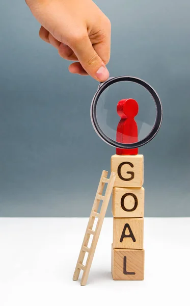 Lupa está mirando a la figura roja de un hombre de pie en una torre de cubos con la palabra objetivo. lograr la meta, dedicación y diligencia, superando obstáculos y pensando extraordinariamente . — Foto de Stock