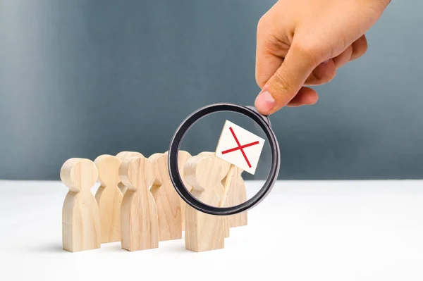 Magnifying glass is looking at the people on protest movement. An angry mob of wooden figures of people with a poster. Social discontent and social tension, protest and disagreement. Disobedience