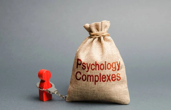 A person is handcuffed with a bag labeled psychological complexes. Feeling of inferiority and low self-esteem, low social skills, sociopathy and lack of communication. Phobias. Psychological help