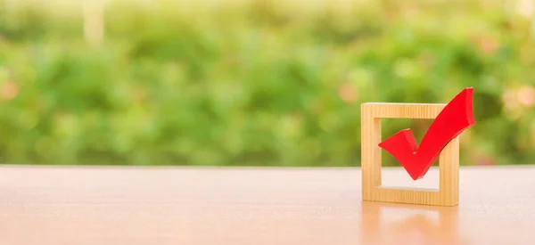 Marca roja de madera para votar en las elecciones. Elecciones presidenciales o parlamentarias, referéndum. Democracia y libertad. Planes de vida y metas. Encuesta de la población, estadísticas. Copiar espacio. Banner —  Fotos de Stock