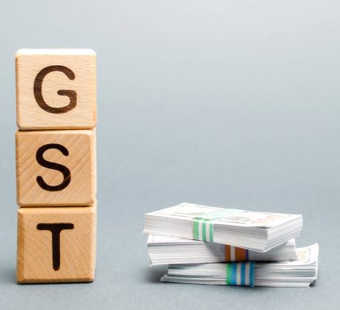Kelime Gst (Mal ve Hizmet Vergisi) ve para ile ahşap bloklar.