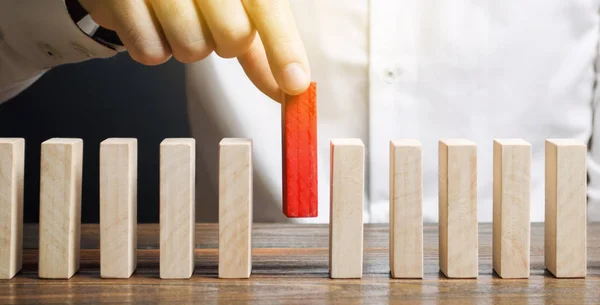 Empresario sostiene un bloque de madera en sus manos. El concepto de selección y gestión de personal dentro del equipo. Despido y contratación de personas para trabajar. Gestión de Recursos Humanos. Selección del líder — Foto de Stock