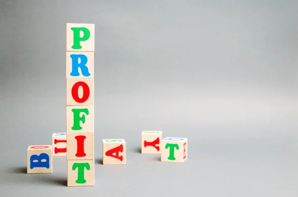 Wooden blocks with the word Profit and randomly scattered cubes. The financial result of the company for a certain period of time. Income. Return on investment. Performance. Profitable business.