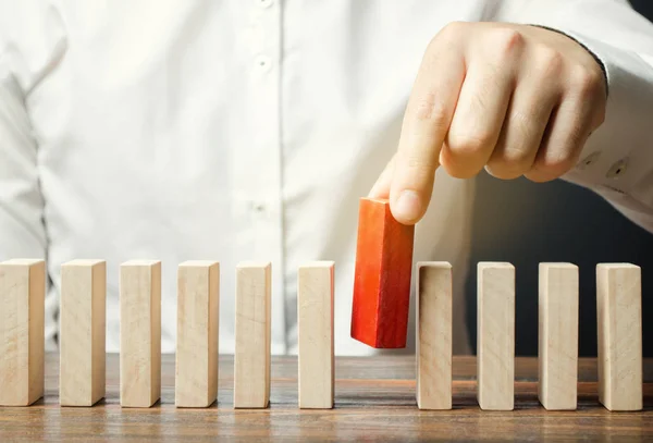 Empresario sostiene un bloque de madera en sus manos. El concepto de selección y gestión de personal dentro del equipo. Despido y contratación de personas para trabajar. Gestión de Recursos Humanos. Selección del líder — Foto de Stock