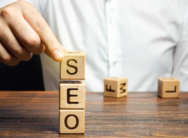 Blocks with the word SEO and businessman. Search Engine Optimization. Increase the quality and quantity of website traffic by increasing the visibility of a website