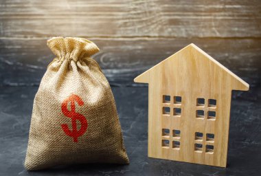 Paralı ve ahşap evli bir çanta. Ev satmak. Daire satın alma. Emlak piyasası. Kiralık konut. Ev fiyatları. Mortgage faizi. Satın alma talebi. Emlak değerlemesi. Sigorta