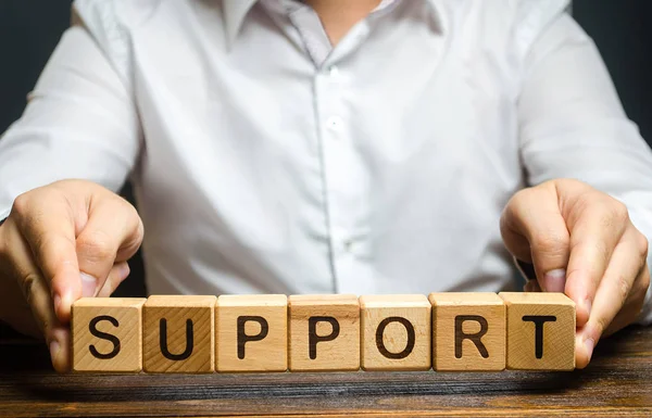 A man holds the word Support. Providing business assistance and support at all stages of startup development. State financial assist, tax breaks relief. Psychological help. Subsidies. — Stock Photo, Image