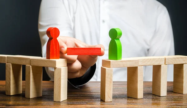 Un hombre hace contacto entre opositores de personas. Árbitro y mediador. Construir puentes, buscar un compromiso en las disputas y la reconciliación de conflictos. Redes en los negocios. Plataforma de negociación — Foto de Stock