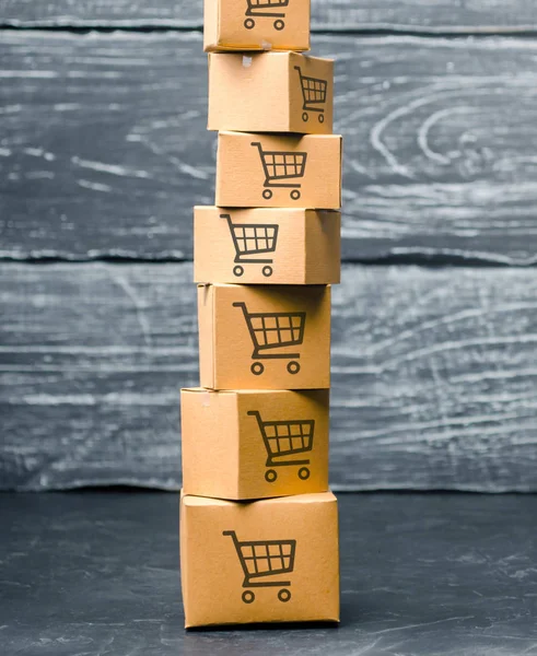 Tower of cardboard boxes with pattern of shopping carts on a blue background. commerce, online shopping. Purchasing power, delivery order. E-commerce, logistics, distribution and sales. — Stock Photo, Image