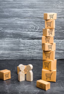 İki tahta insan bir kutu kulesinin yanında duruyor. alıcı ve satıcı, üretici ve perakendeci. İş ve ticaret. Ticaret anlaşmasının şartlarının tartışılması, mal ve hizmet alımları.