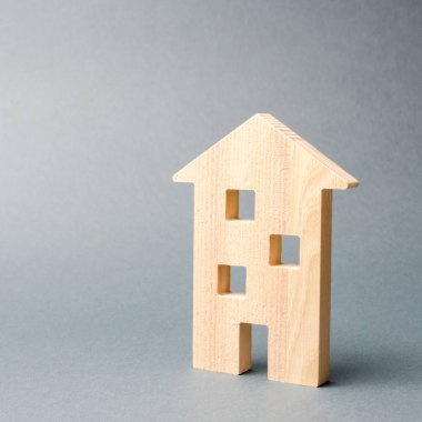 Gri bir arka plan üzerinde minyatür ahşap ev. Emlak. Uzun süreli kiralık daireler. Genç aileler için uygun fiyatlı konut. Ucuz emlak kredileri. Mortgage ve kredi. Yeni binaların inşaatı
