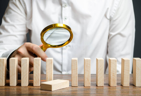 The wooden block fell out of order. The study of business mistakes. Weak link. Unreliable and unsuccessful plan. Risk assessment and strategy creation. Costs and ineffective management. Businessman