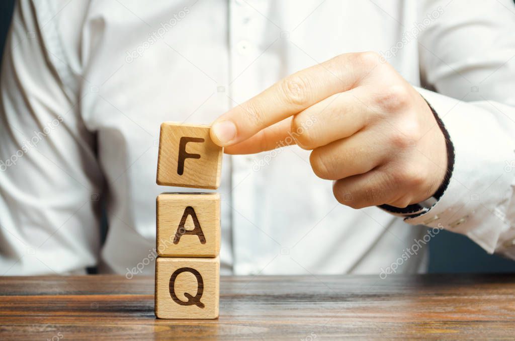 Businessman puts wooden blocks with the word FAQ (frequently asked questions). Collection of frequently asked questions on any topic and answers to them. Instructions and rules on Internet sites