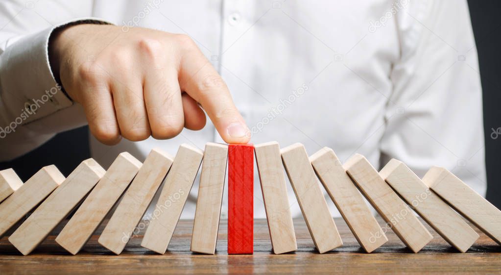 Businessman stops collapse domino effect. Stress resistance business. Financial stability. Recovery business. Evaluation of cash risks. Creating a strategy. Management and planning. Decision making