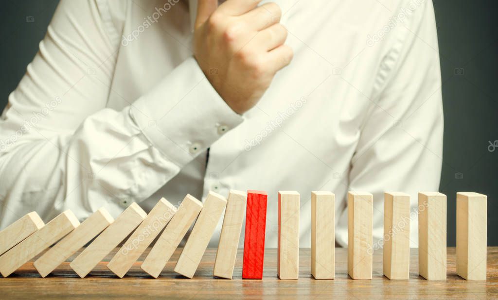 Wooden blocks and the effect of dominoes. Risk management concept. Successful strong business and problem solving. Reliable leader. Stop the destructive processes. Strategy development.