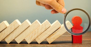 İşadamı domino taşının düşüşünü durdurdu. Risk yönetimi konsepti. Başarılı, güçlü bir iş ve problem çözme. Güvenilir bir lider. Yıkıcı işlemleri durdurun. Strateji geliştirme. Borç yeniden yapılandırması
