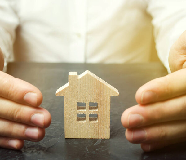 Страховой агент защищает дом жестом защиты. Концепция страхования имущества и жилья. Безопасность в доме. Недвижимость
