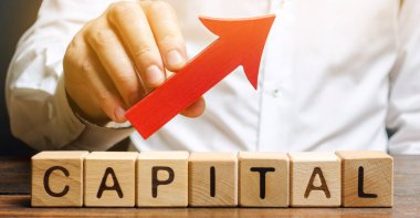 Adam kırmızı oku kelime başkentinin üstünde tutuyor. Ulusal ekonomide yatırımı ve yabancı sermayeyi artırın. İş ortamını iyileştirmek ve çekiciliği artırmak. Ekonominin büyümesi ve istikrarı