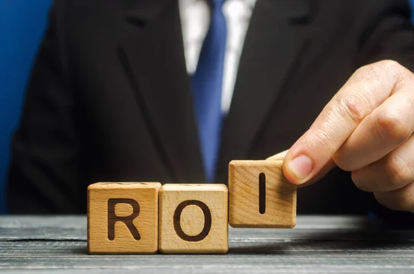 사업가는 Roi 단어와 블록을 놓습니다 개념으로 돌아가 투자의 수익성과 Romi — 스톡 사진