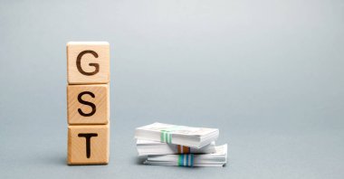 GST (Mal ve Hizmetler Vergisi) ve parayla tahta bloklar. Vergi, mal ve hizmetlerin satışına dayatılıyor.