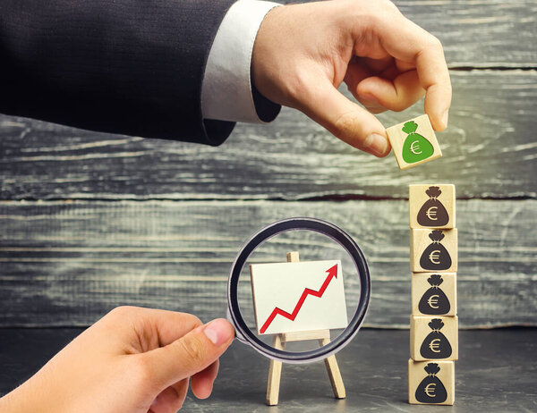 Бизнесмен ставит блок с изображением евро. Увеличить бюджет и прибыль в команде. Накопление капитала, успешный бизнес. Инвестиционный фонд. Коплю деньги. Экономический бум. Chart