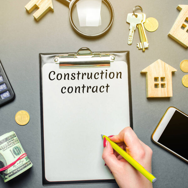 Table with wooden houses, calculator, coins, magnifying glass with the word Construction contract. Planning the construction of real estate buildings. Investing. Develop an action plan. Flat lay