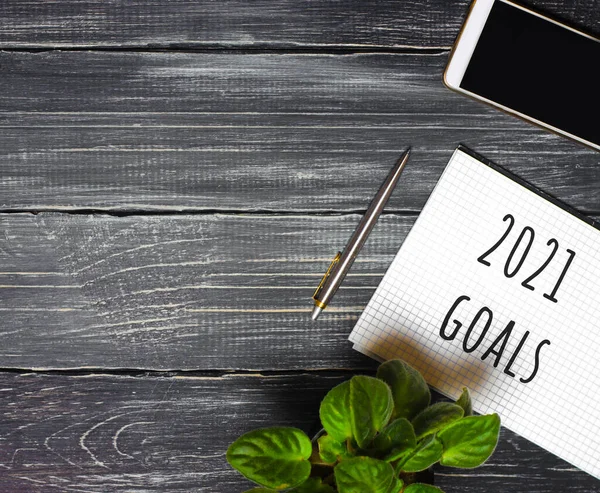 2021 Goals concept. Desktop with notebook, phone, pen. Motivation, inspiration. Planning, plans and tasks. New business ideas. Setting goal, target.