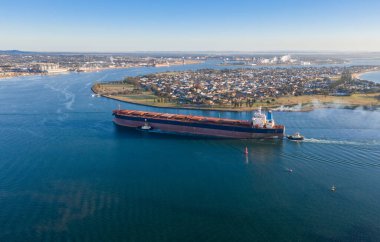 Newcastle NSW Avustralya 'da römorkörler tarafından bir kömür gemisi limana getirilir. Newcastle dünyanın en işlek kömür ihracat limanlarından biridir. Stockton banliyösü, Kooragang liman ve kömür yükleme tesislerinde penisler üzerinde görülebilir.