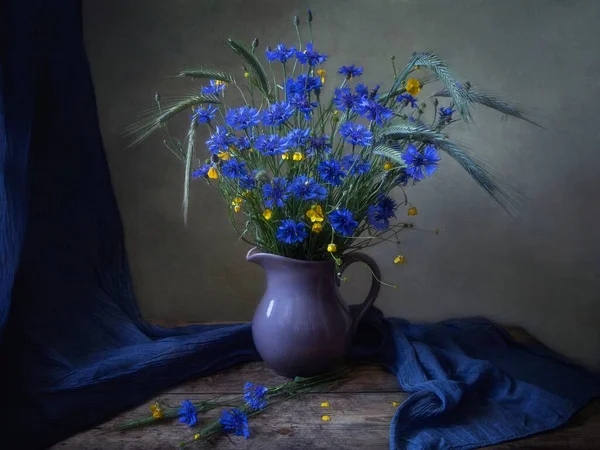 Still life with bouquet of field flowers and ears of rye
